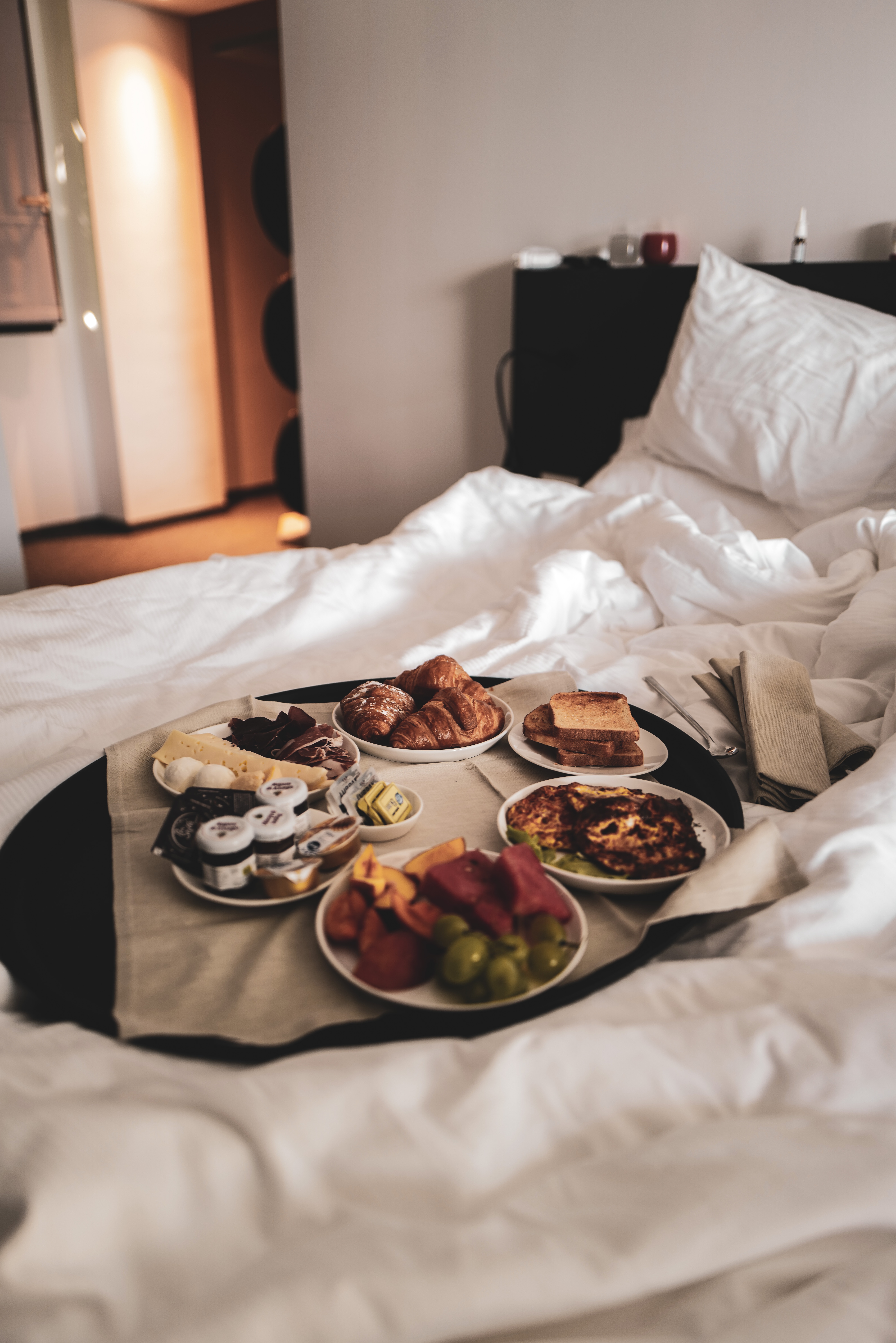 Speisen auf 6 Tellern auf einem Bett im Hotelzimmer